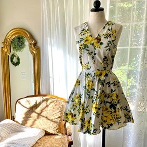 Vintage inspired short white and yellow floral print dress with pockets.